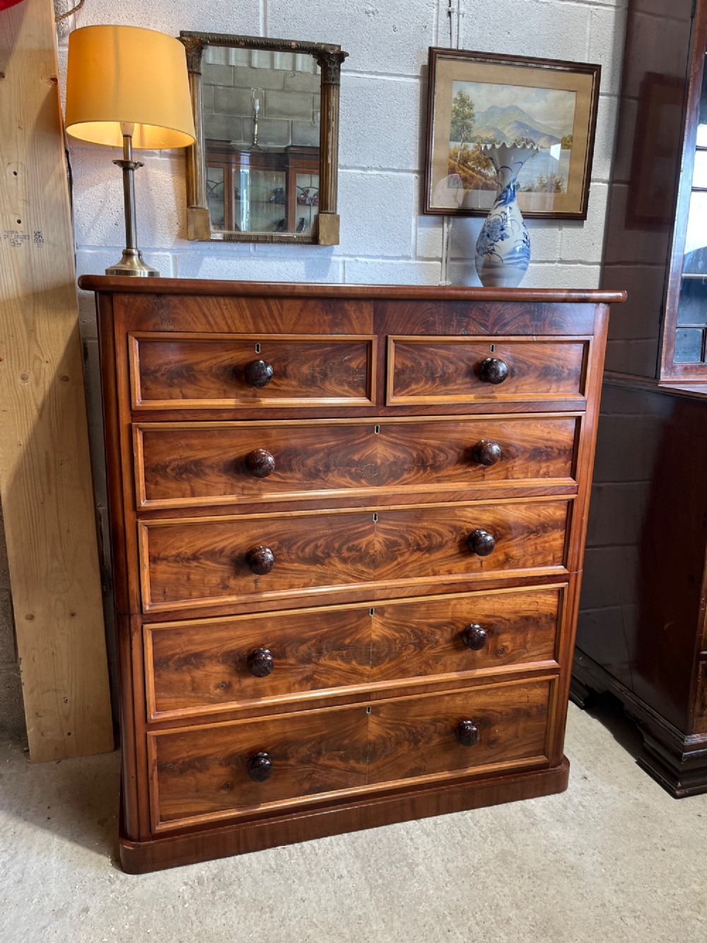 A tall nineteenth-century mahogany chest of drawers featuring two short top drawers above four long drawers with turned wooden handles on a solid plinth base. View VIII