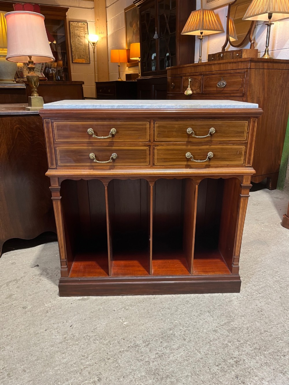 A late 19th-century inlaid mahogany cabinet featuring a grey marble surface, four drawers with string inlay and brass drop handles, above four vertical open storage divisions. View III