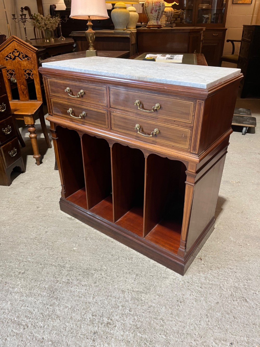 A late 19th-century inlaid mahogany cabinet featuring a grey marble surface, four drawers with string inlay and brass drop handles, above four vertical open storage divisions. View VIII