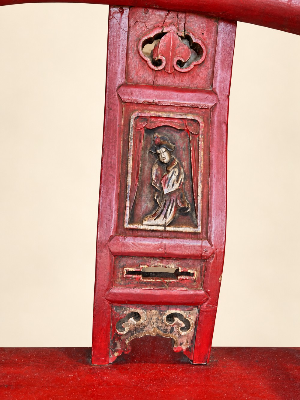 A traditional red lacquered Chinese armchair featuring a curved horseshoe backrest and a carved central splat. View V