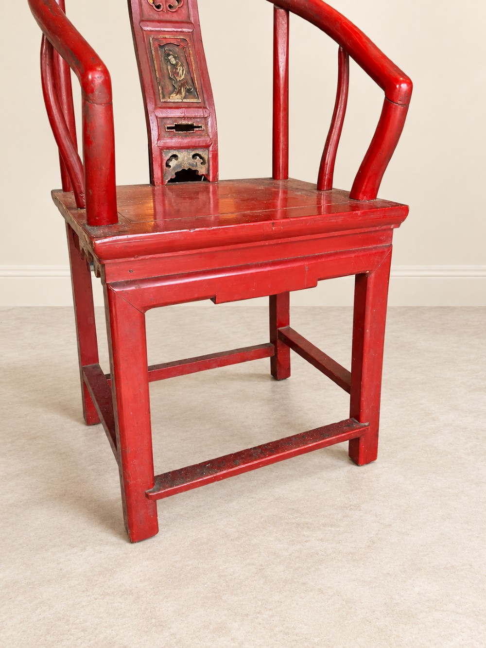 A traditional red lacquered Chinese armchair featuring a curved horseshoe backrest and a carved central splat. View VII