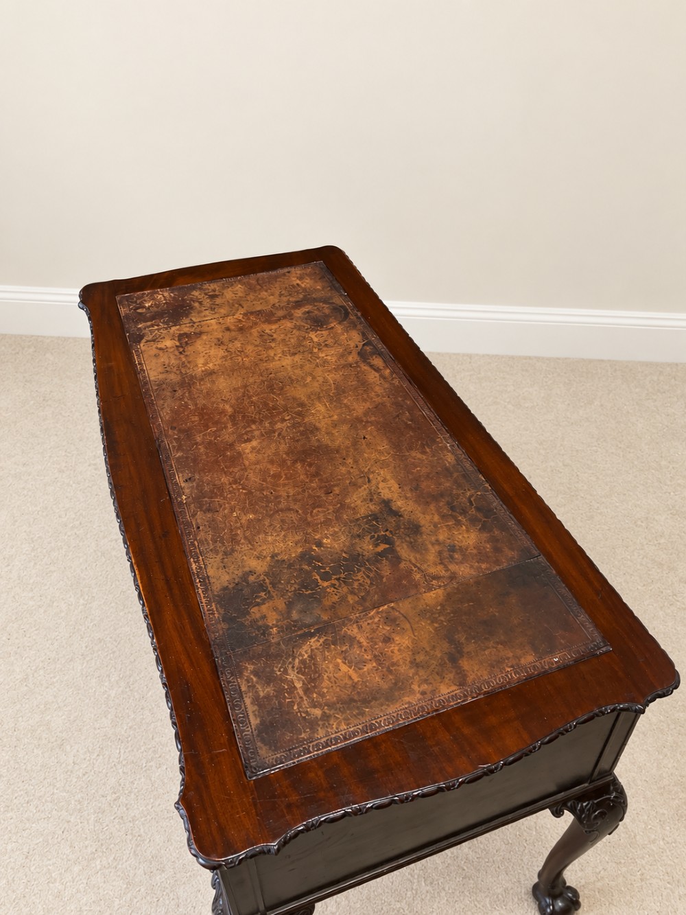A dark mahogany writing table featuring three drawers, a carved shell apron, and cabriole legs with ball-and-claw feet. View IV