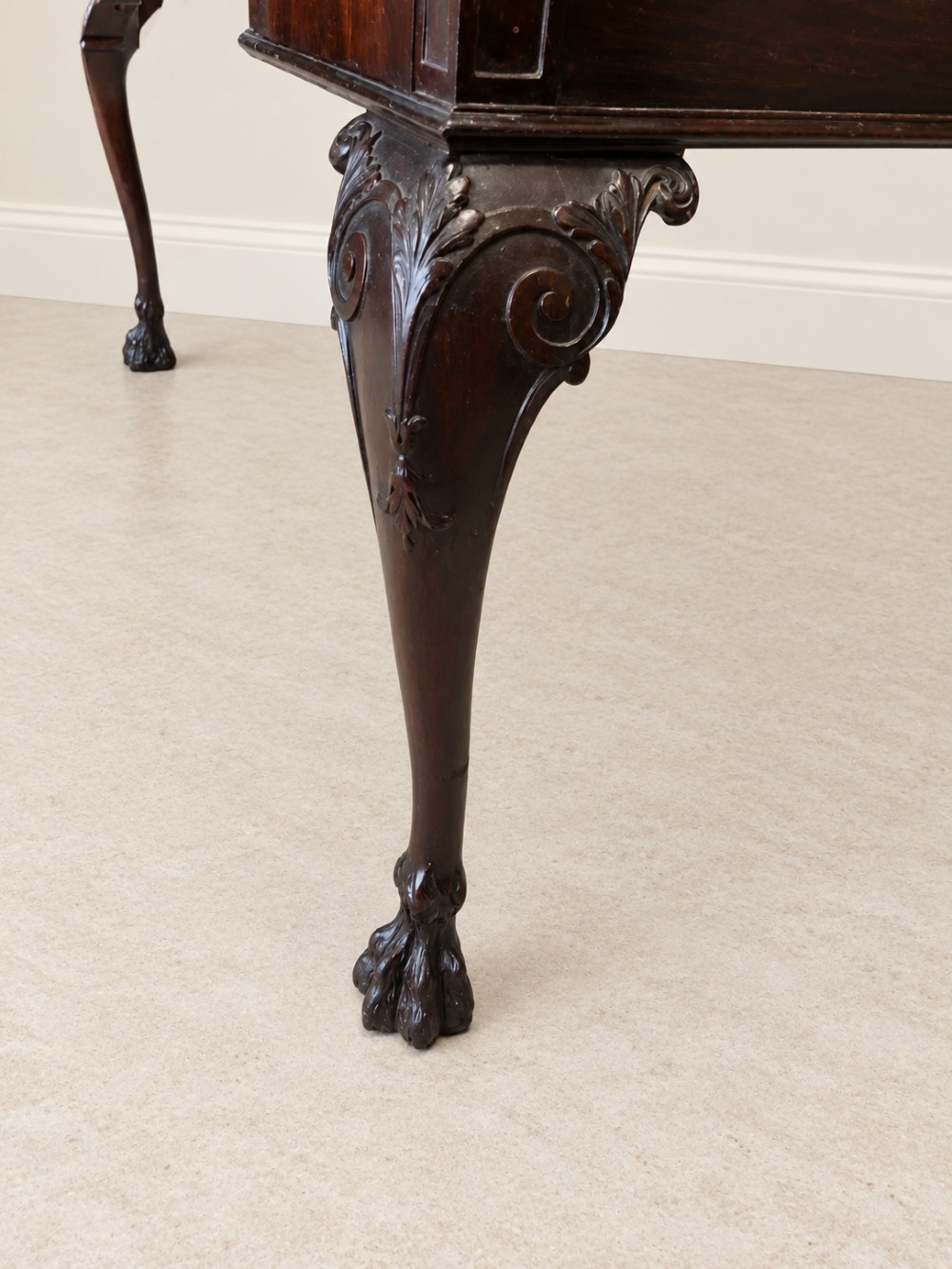 A dark mahogany writing table featuring three drawers, a carved shell apron, and cabriole legs with ball-and-claw feet. View V