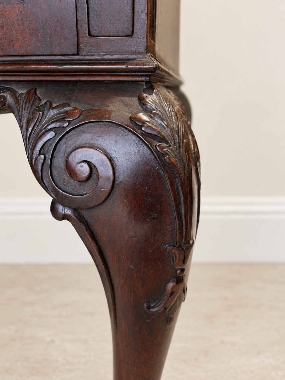 A dark mahogany writing table featuring three drawers, a carved shell apron, and cabriole legs with ball-and-claw feet. View X