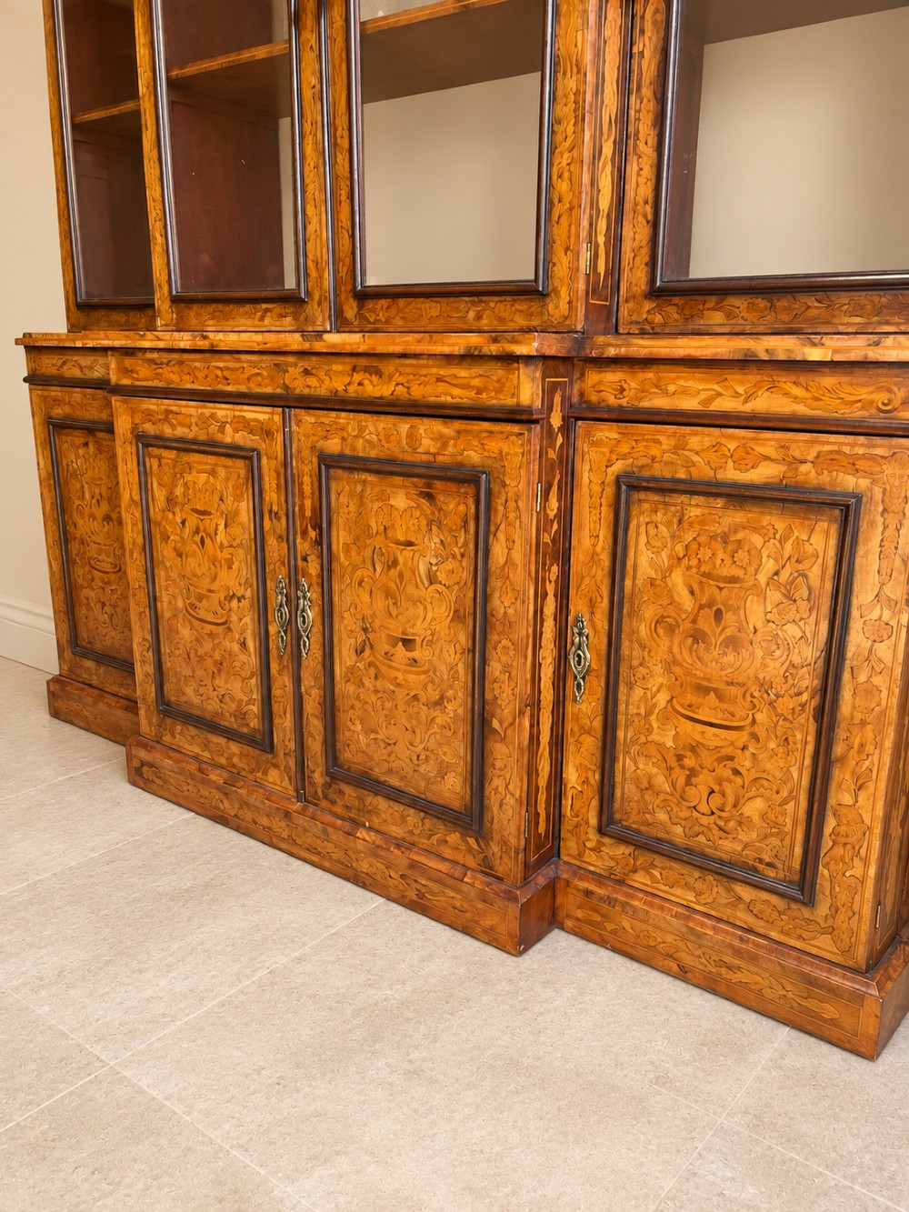 A nineteenth-century inlaid walnut breakfront bookcase featuring four upper glazed doors and four lower wooden cupboard doors decorated with floral marquetry. View IV