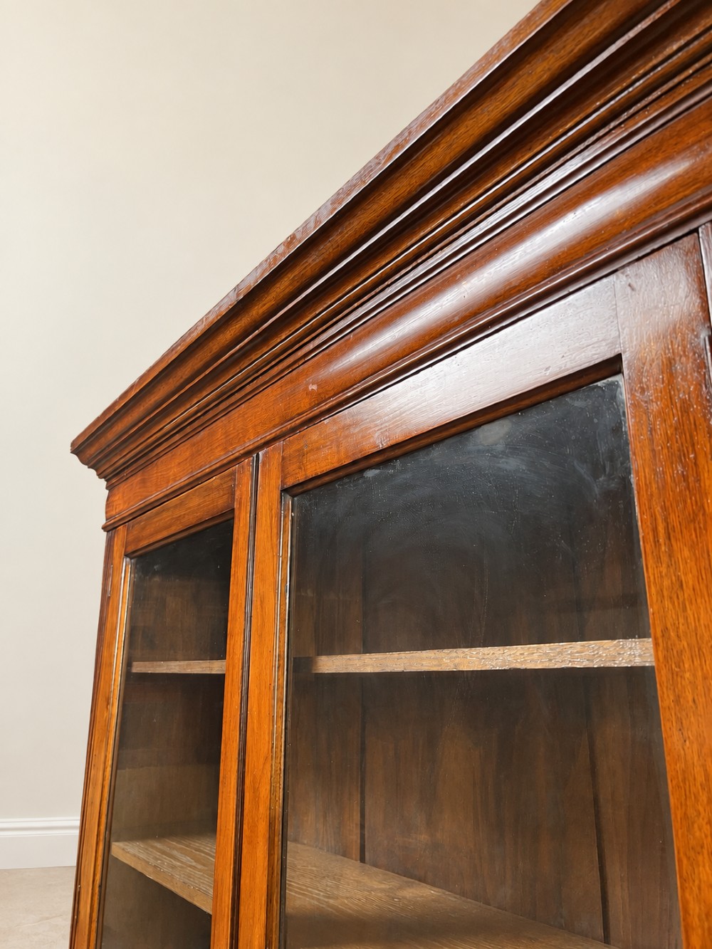A late nineteenth-century mahogany bookcase featuring two glass-front upper doors above two drawers and a double cupboard base. View III