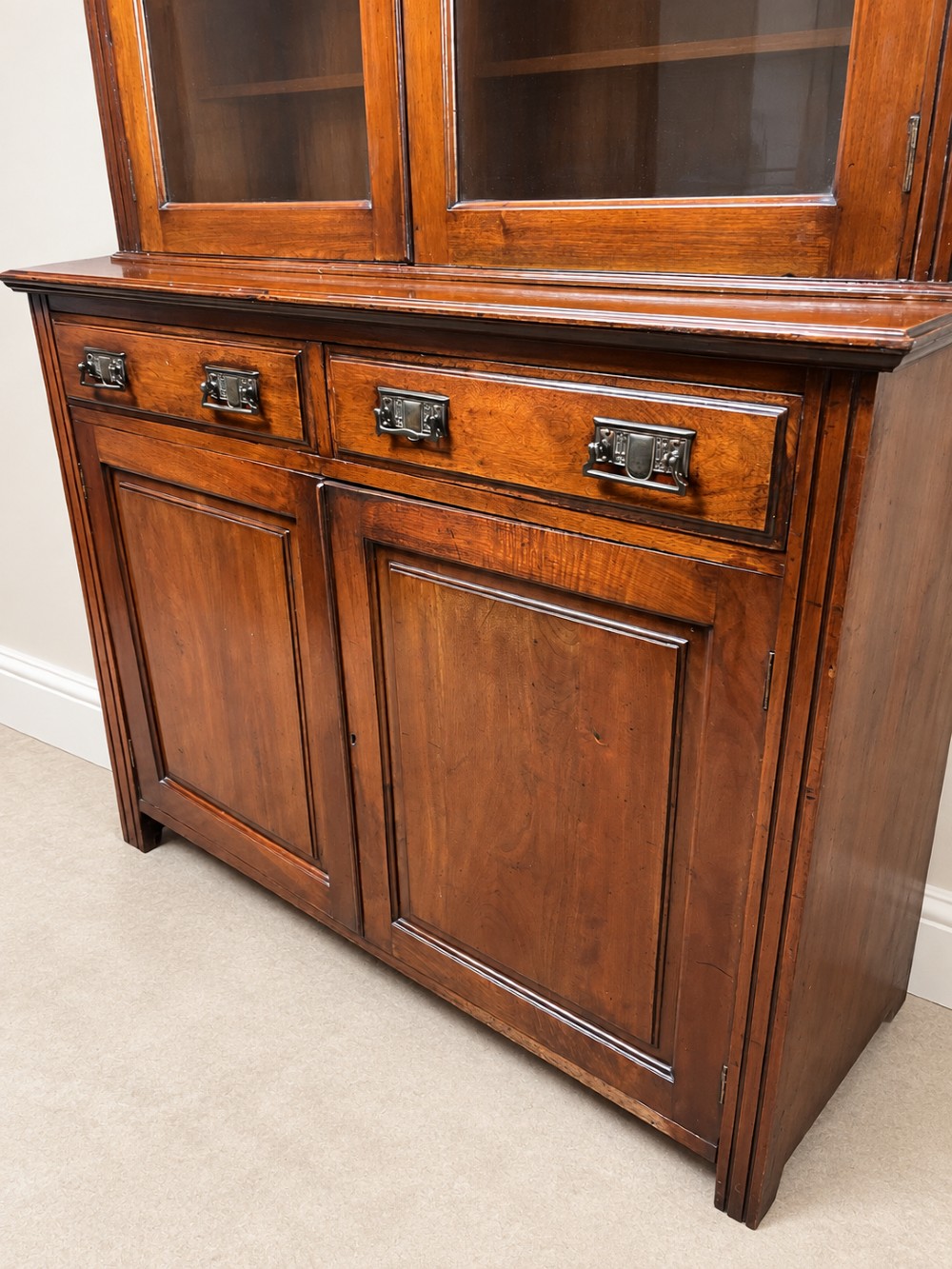 A late nineteenth-century mahogany bookcase featuring two glass-front upper doors above two drawers and a double cupboard base. View VIII
