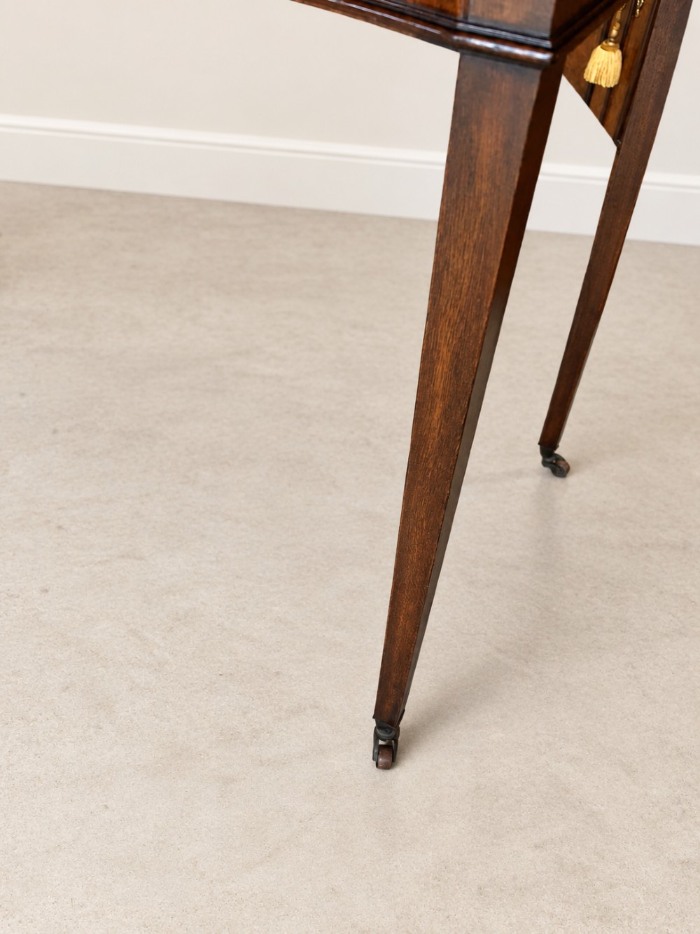 A Georgian style mahogany side table featuring a curved front apron, two drawers with brass swan-neck handles, a low shaped gallery back, and square tapered legs on castors. View III