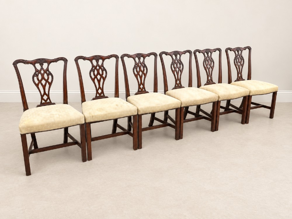 A set of six Chippendale style mahogany dining chairs featuring intricately carved pierced back splats and cream upholstered seats. View III