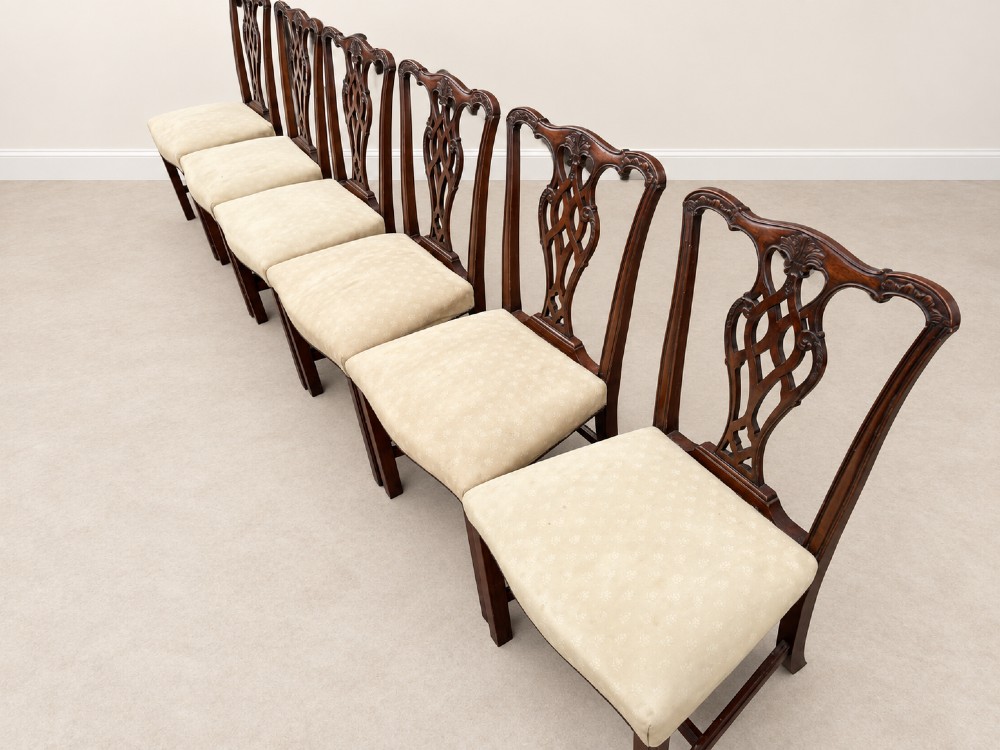 A set of six Chippendale style mahogany dining chairs featuring intricately carved pierced back splats and cream upholstered seats. View VIII