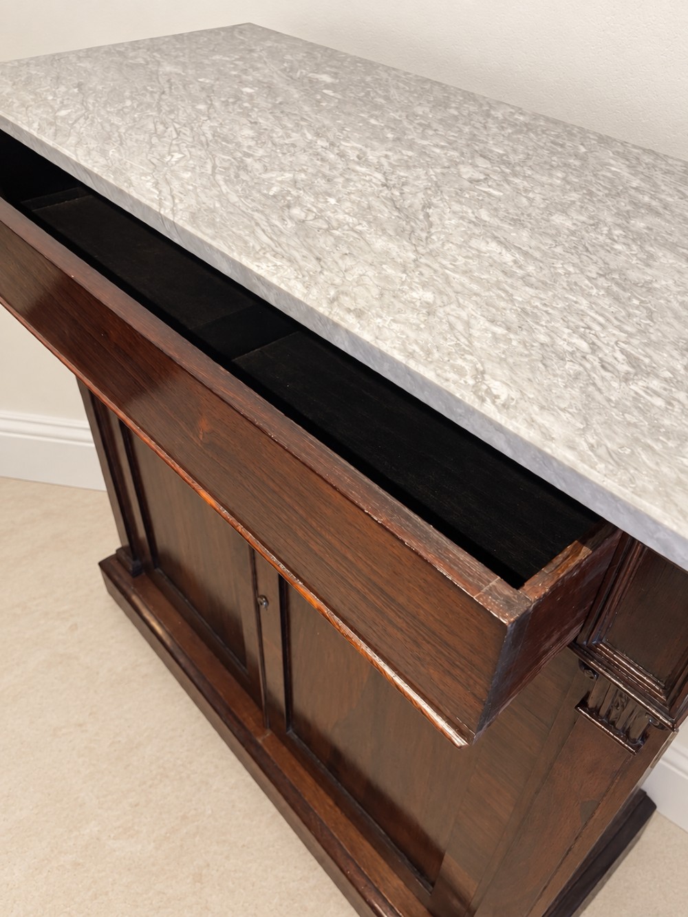 A pair of 19th-century Regency dark rosewood cupboards featuring white marble tops and panelled double doors on plinth bases. View X