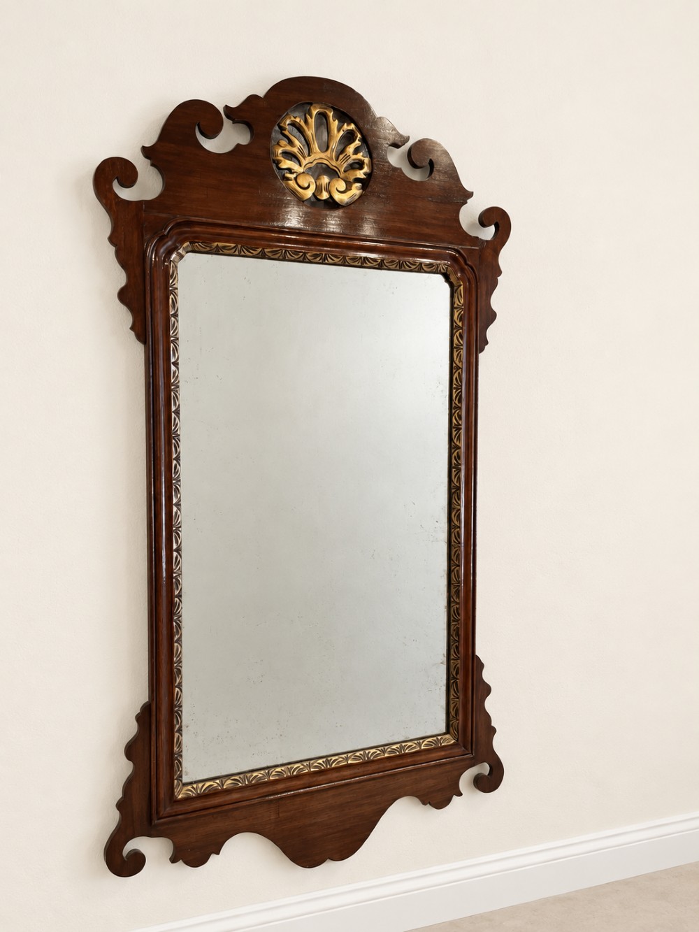 A Georgian mahogany fretwork wall mirror featuring a scrollwork frame, gilt shell cresting detail, and a gilded inner border. View II