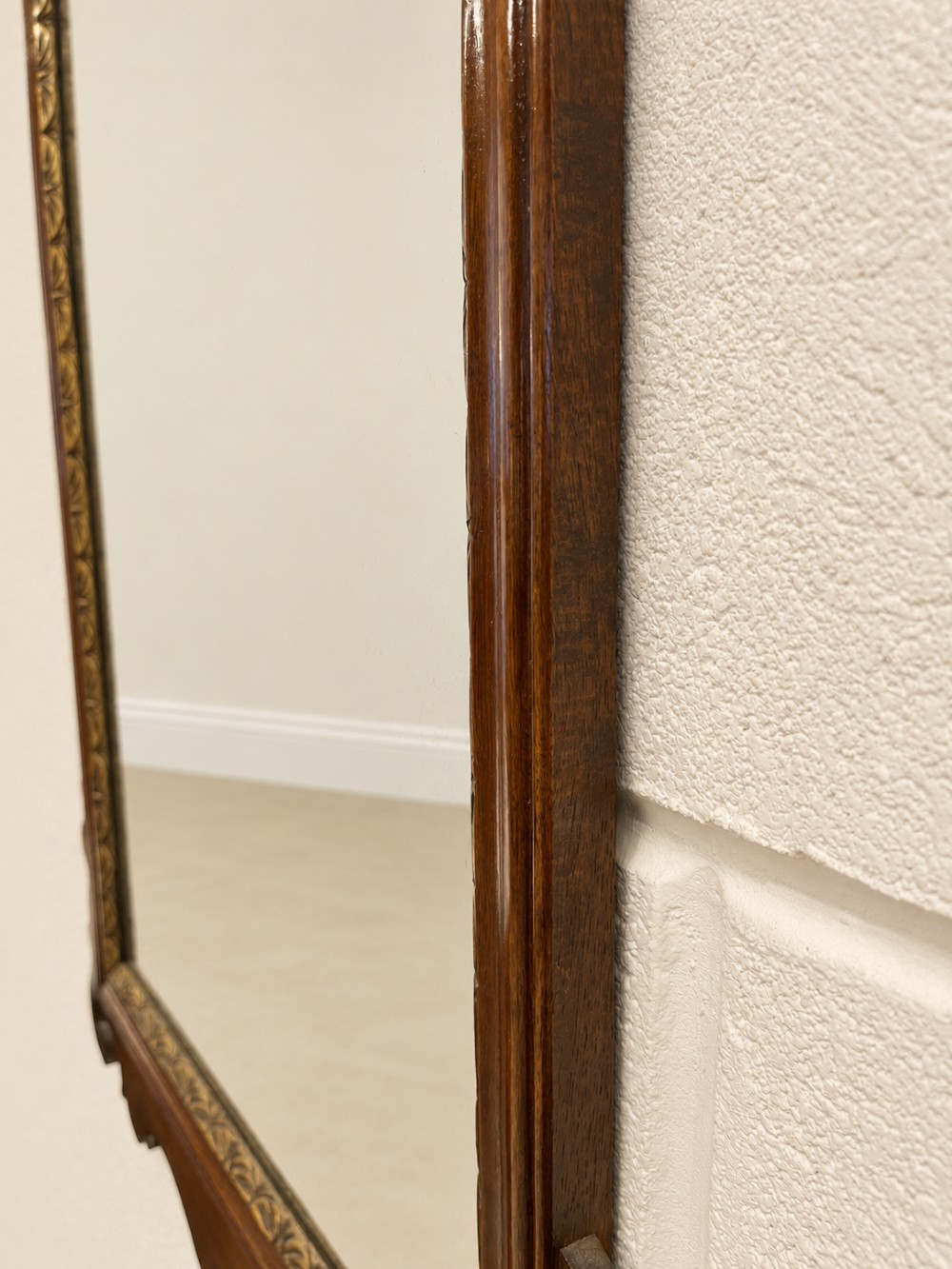 A Georgian mahogany fretwork wall mirror featuring a scrollwork frame, gilt shell cresting detail, and a gilded inner border. View IV