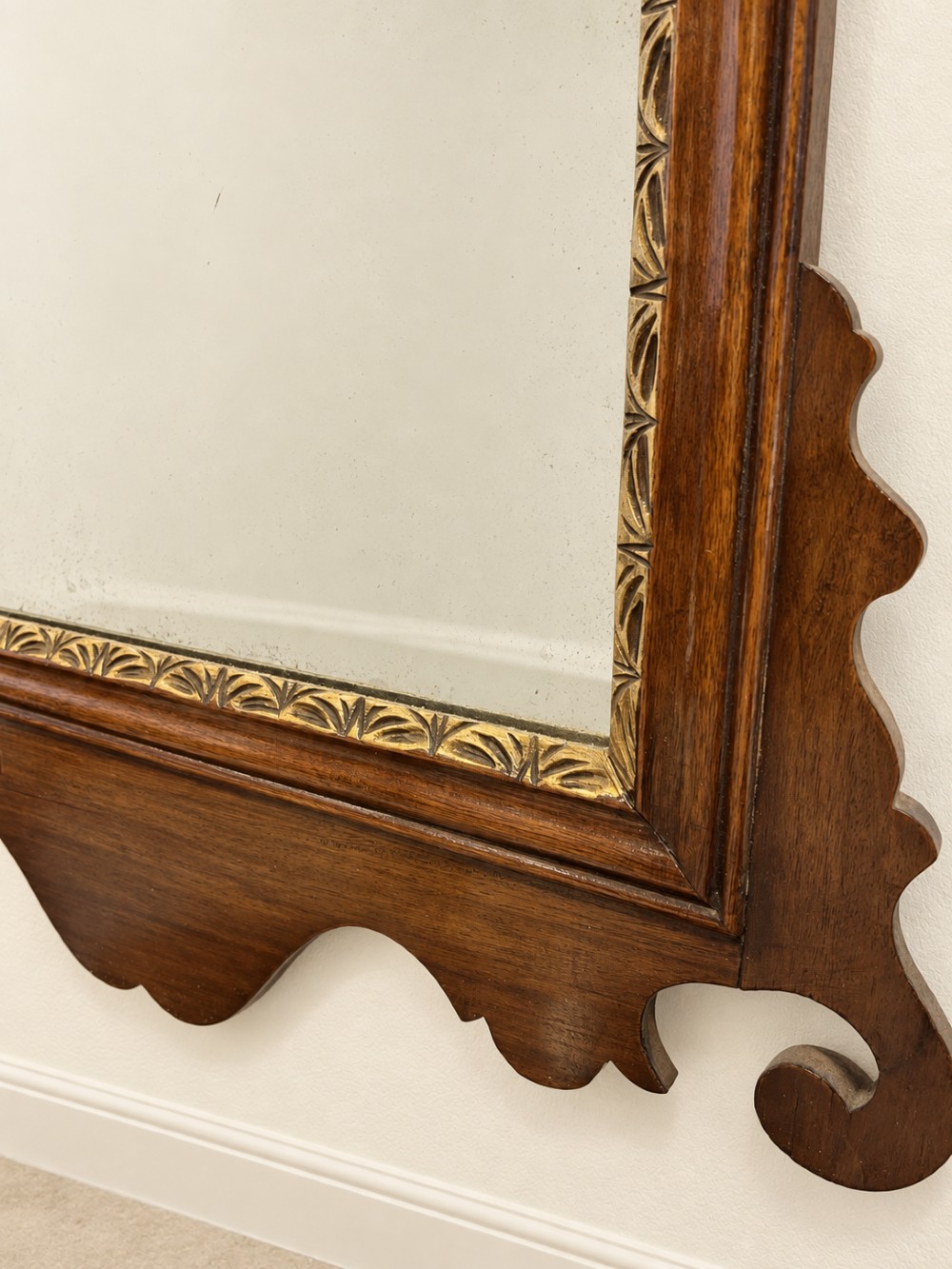 A Georgian mahogany fretwork wall mirror featuring a scrollwork frame, gilt shell cresting detail, and a gilded inner border. View VI