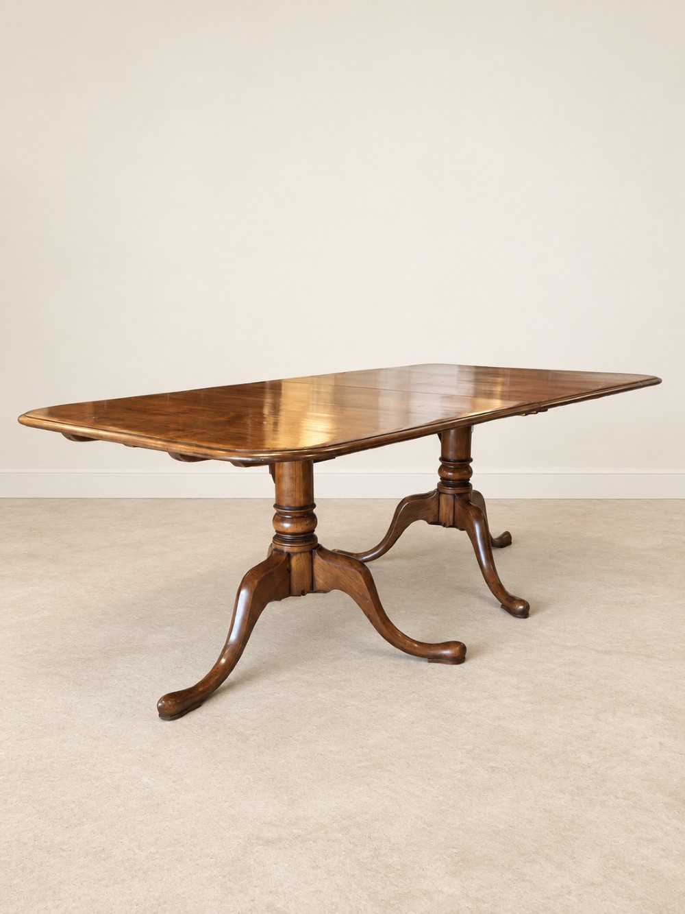 A large extendable mahogany dining table surrounded by ten matching wooden chairs with patterned pink fabric seats. View XV