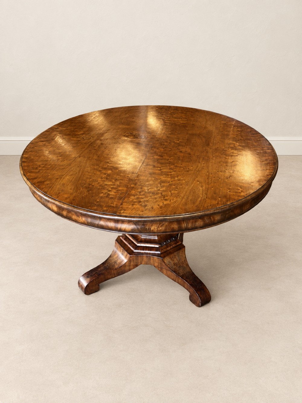 A 19th-century circular mahogany dining table featuring a figured grain top, fluted central pedestal column, and a quadform platform base on scroll feet. View III