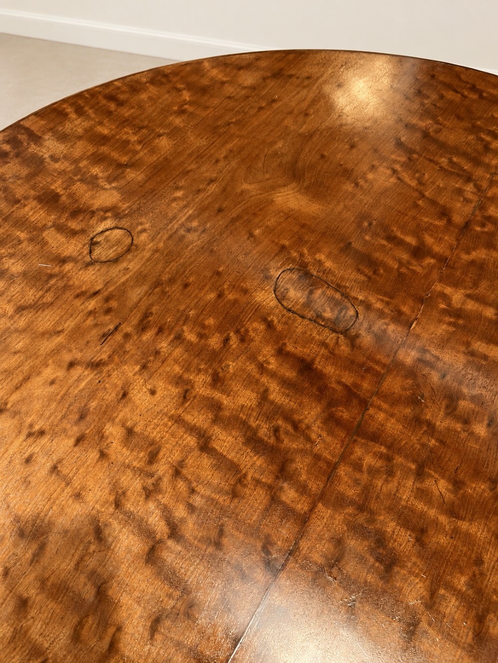A 19th-century circular mahogany dining table featuring a figured grain top, fluted central pedestal column, and a quadform platform base on scroll feet. View VII