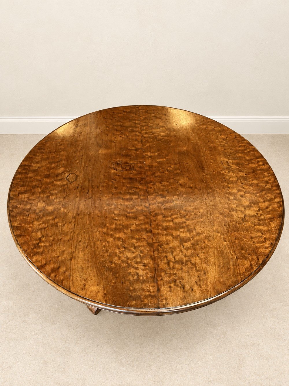 A 19th-century circular mahogany dining table featuring a figured grain top, fluted central pedestal column, and a quadform platform base on scroll feet. View VIII