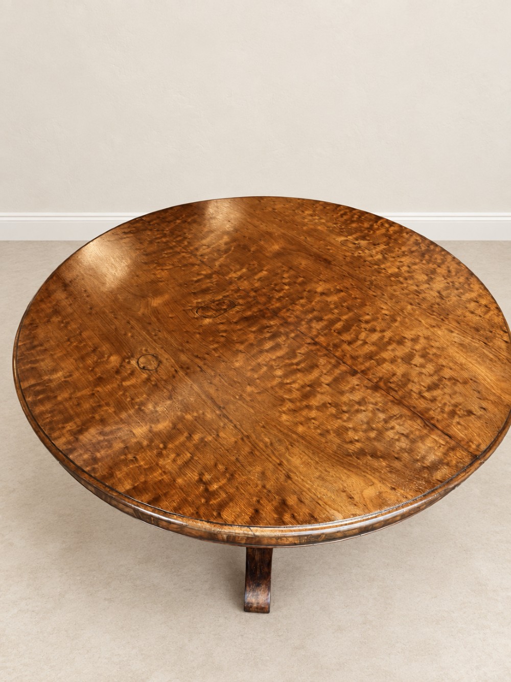 A 19th-century circular mahogany dining table featuring a figured grain top, fluted central pedestal column, and a quadform platform base on scroll feet. View IX