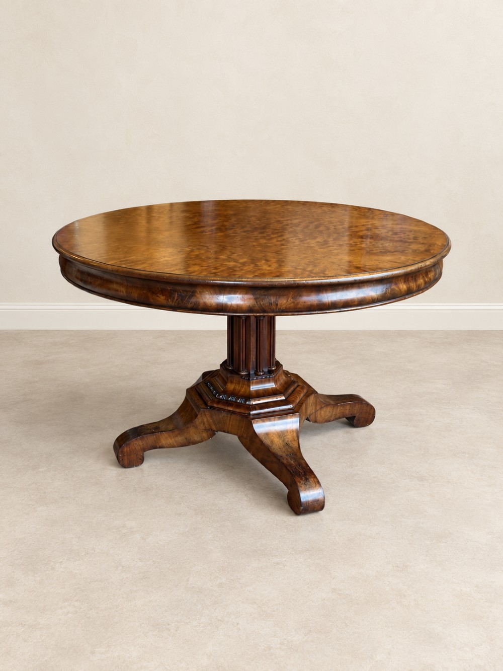 A 19th-century circular mahogany dining table featuring a figured grain top, fluted central pedestal column, and a quadform platform base on scroll feet. View X