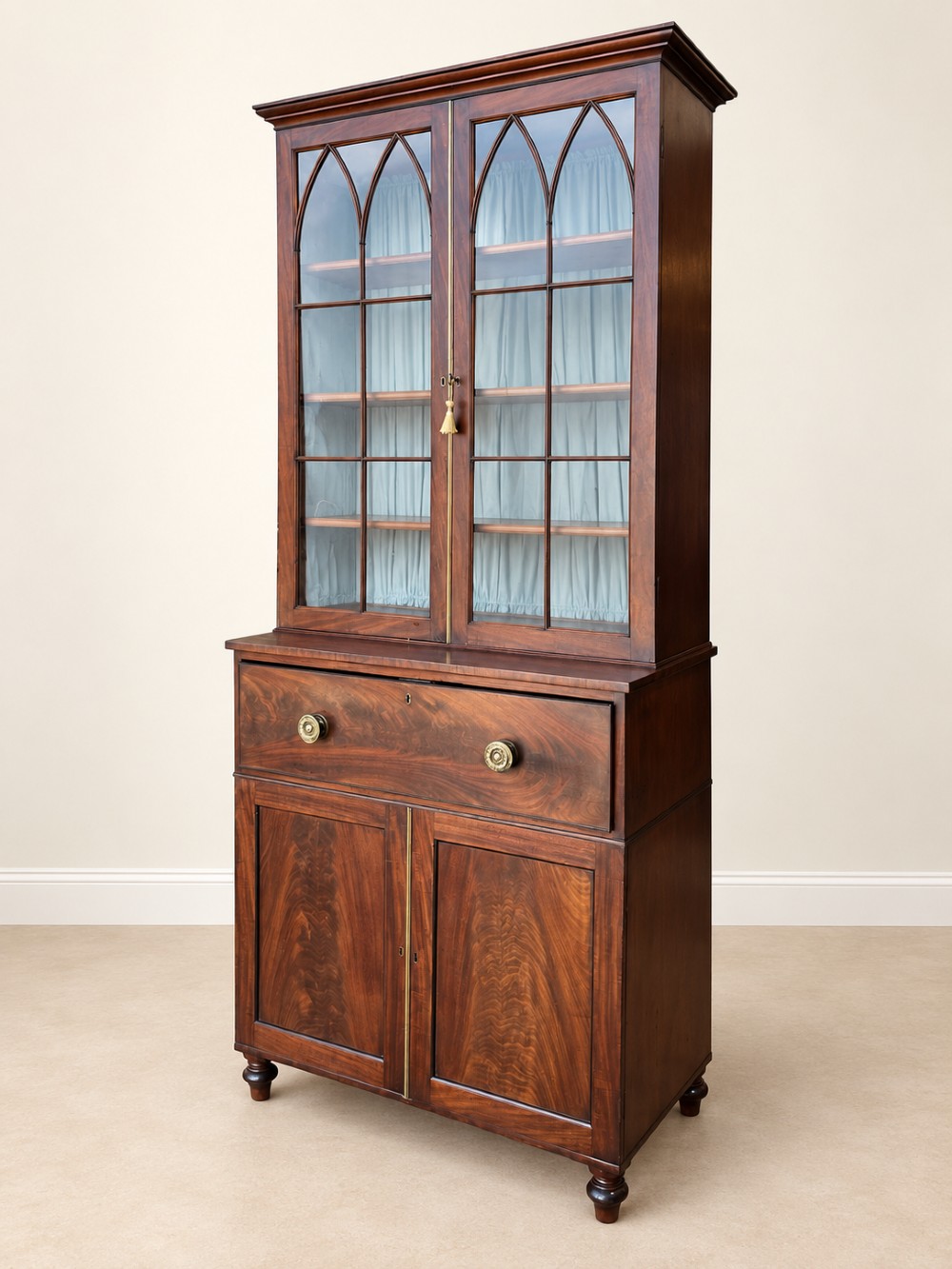 A tall 19th-century mahogany secretaire bookcase featuring upper glazed doors with Gothic arched astragal glazing, a deep drawer, and a lower two-door cupboard standing on turned feet. View II