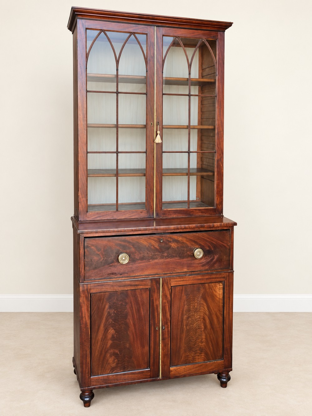 A tall 19th-century mahogany secretaire bookcase featuring upper glazed doors with Gothic arched astragal glazing, a deep drawer, and a lower two-door cupboard standing on turned feet. View III
