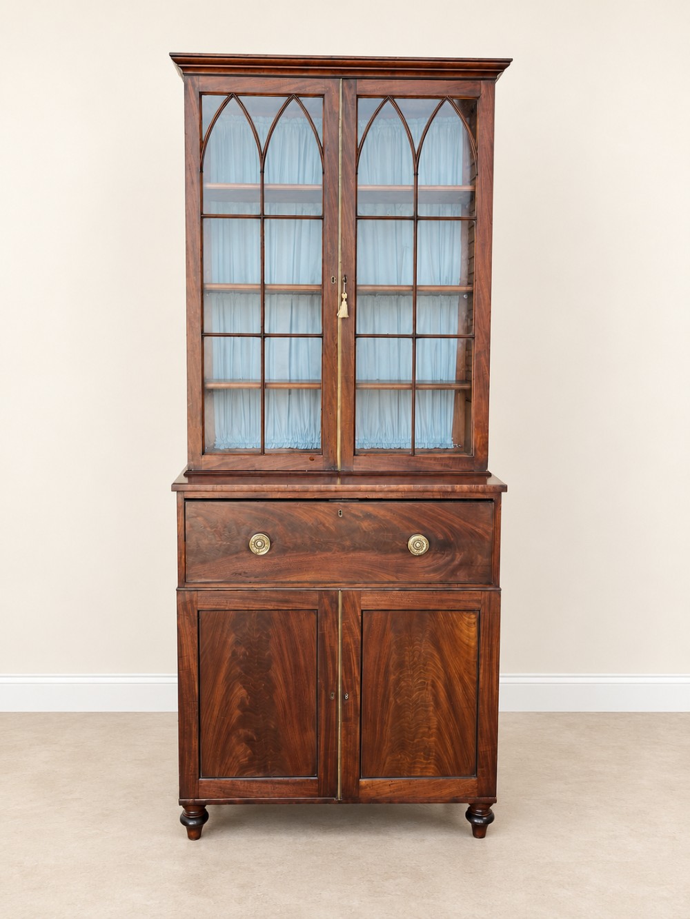 A tall 19th-century mahogany secretaire bookcase featuring upper glazed doors with Gothic arched astragal glazing, a deep drawer, and a lower two-door cupboard standing on turned feet. View IV