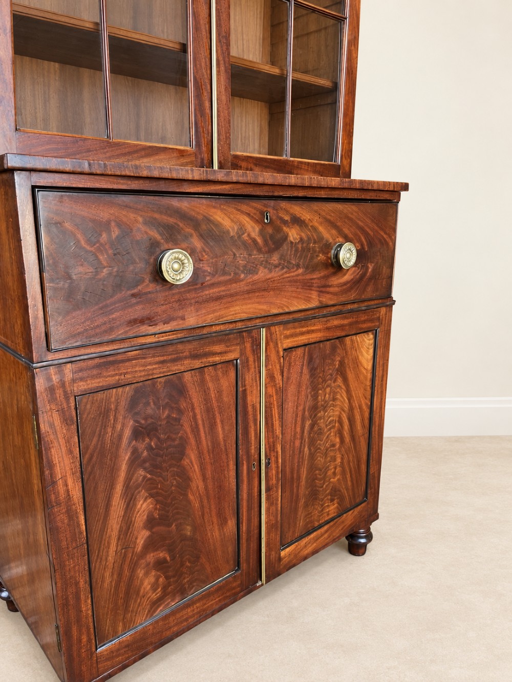A tall 19th-century mahogany secretaire bookcase featuring upper glazed doors with Gothic arched astragal glazing, a deep drawer, and a lower two-door cupboard standing on turned feet. View V