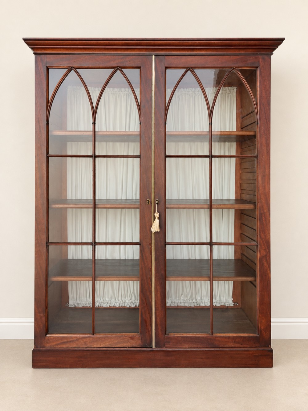 A tall 19th-century mahogany secretaire bookcase featuring upper glazed doors with Gothic arched astragal glazing, a deep drawer, and a lower two-door cupboard standing on turned feet. View VI