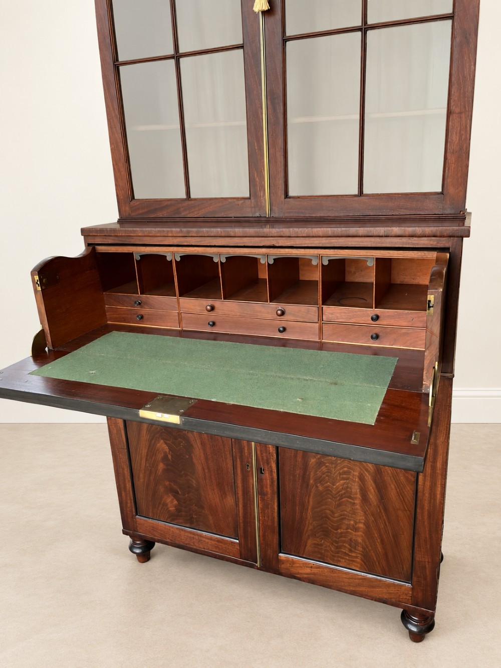A tall 19th-century mahogany secretaire bookcase featuring upper glazed doors with Gothic arched astragal glazing, a deep drawer, and a lower two-door cupboard standing on turned feet. View VII