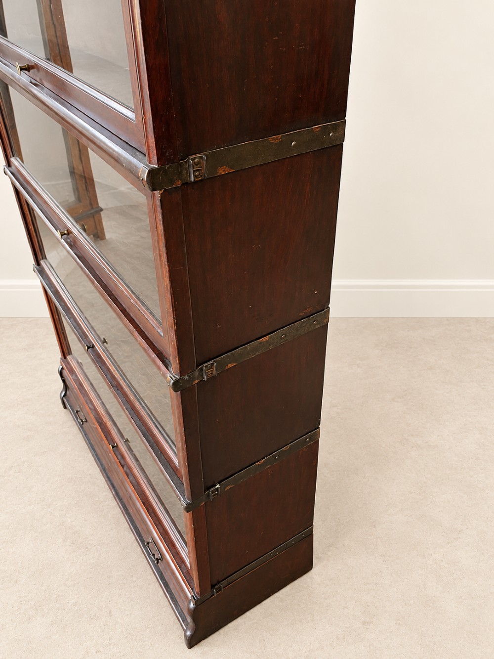 A four-tier dark mahogany Globe Wernicke sectional bookcase featuring glazed lift-up doors and a bottom drawer with brass handles. View VII