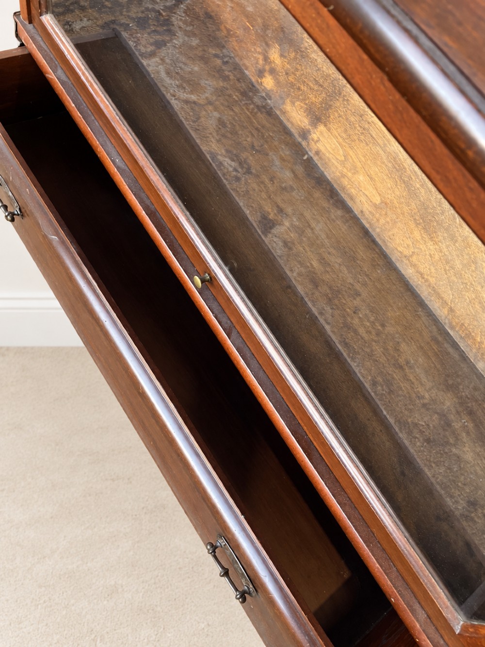 A four-tier dark mahogany Globe Wernicke sectional bookcase featuring glazed lift-up doors and a bottom drawer with brass handles. View X