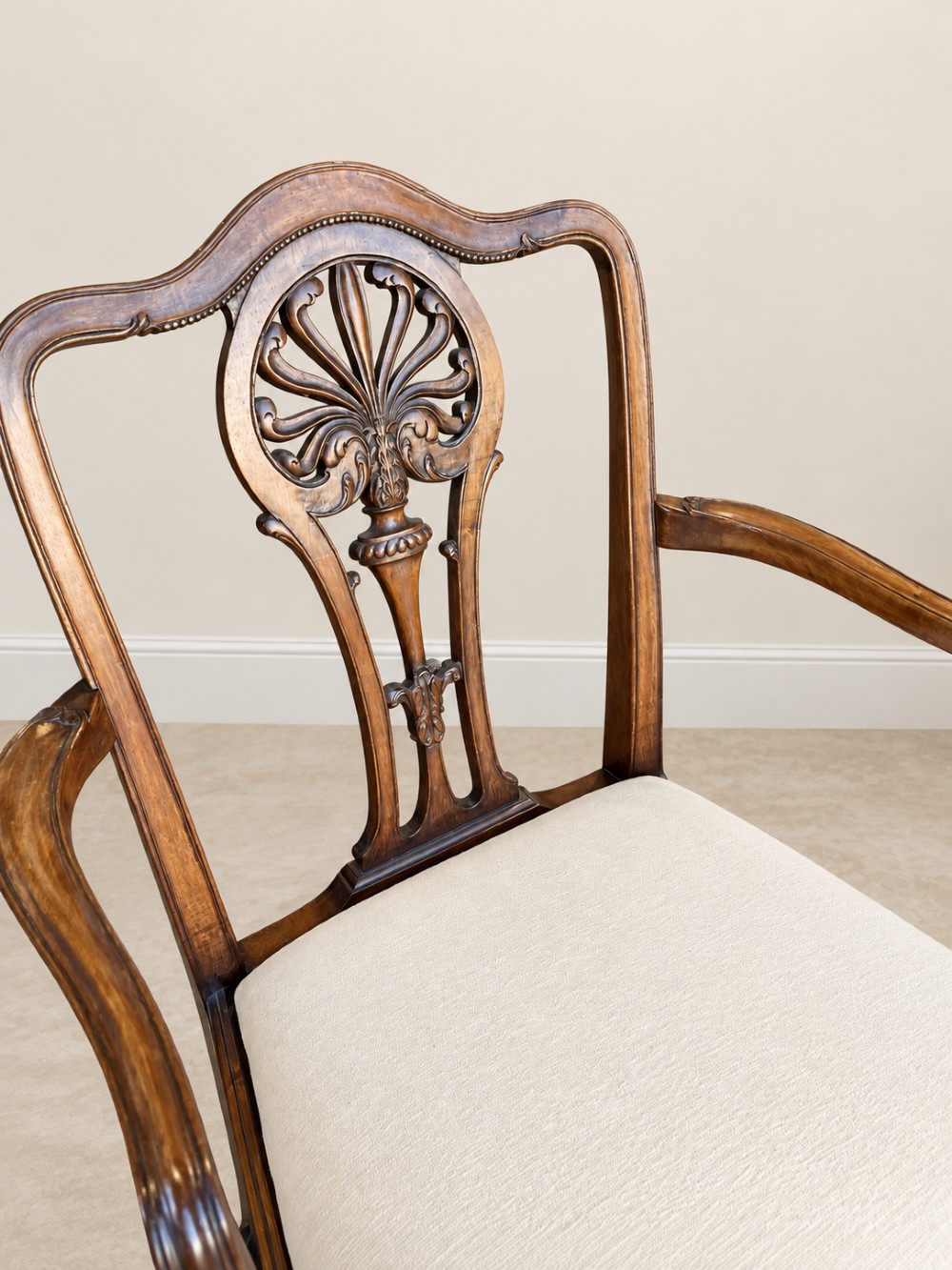 A set of six mahogany dining chairs featuring intricate carved splat backs and neutral cream fabric seats. View IV
