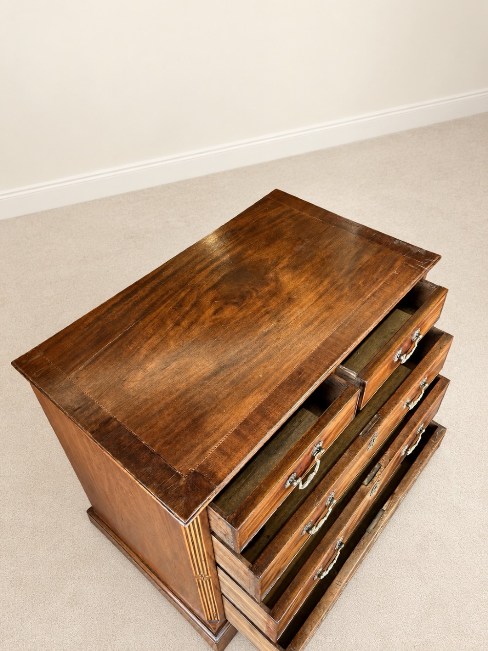 An antique George III mahogany chest of drawers featuring two short over three long drawers with decorative brass swan-neck handles and bracket feet. View XI