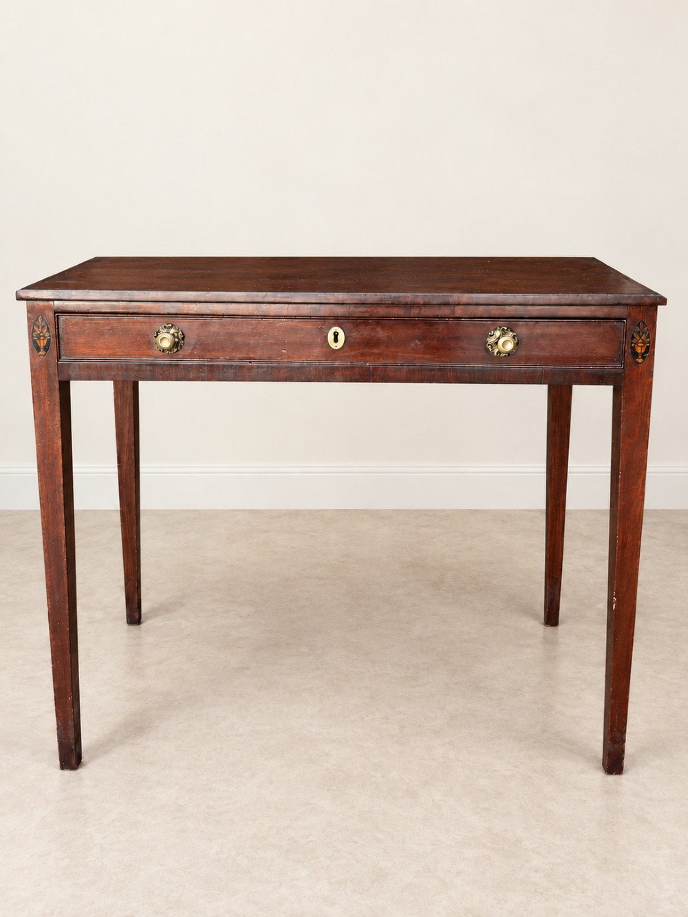An antique nineteenth-century mahogany side table featuring a single drawer, brass handles, decorative oval floral inlay, and slender tapered legs. View II