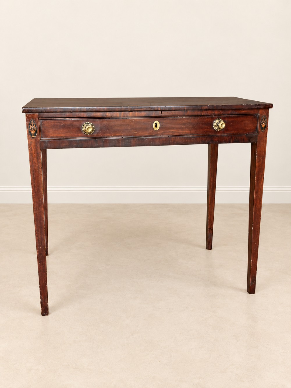 An antique nineteenth-century mahogany side table featuring a single drawer, brass handles, decorative oval floral inlay, and slender tapered legs. View III