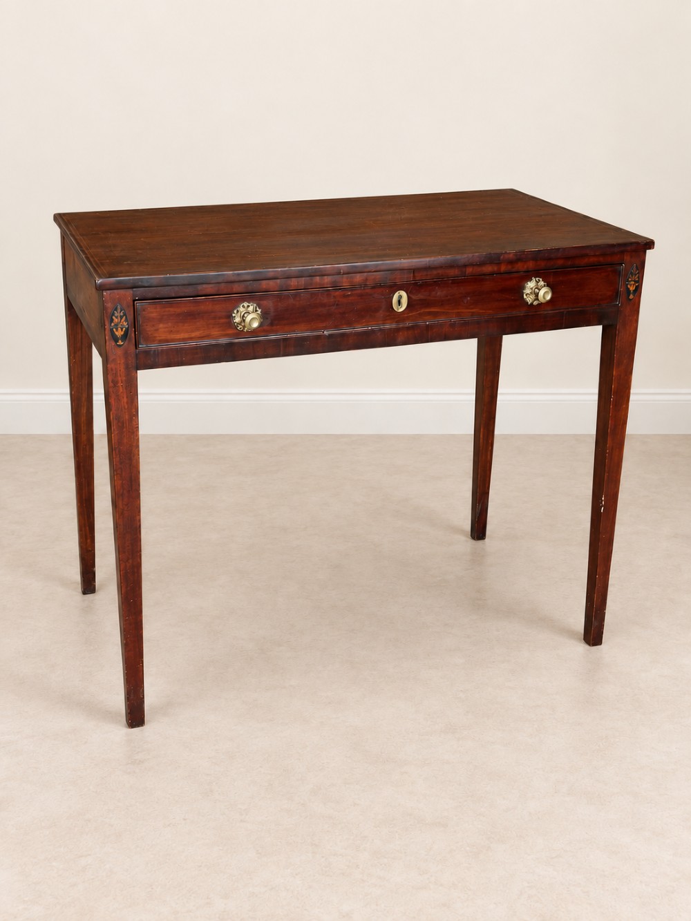 An antique nineteenth-century mahogany side table featuring a single drawer, brass handles, decorative oval floral inlay, and slender tapered legs. View IV