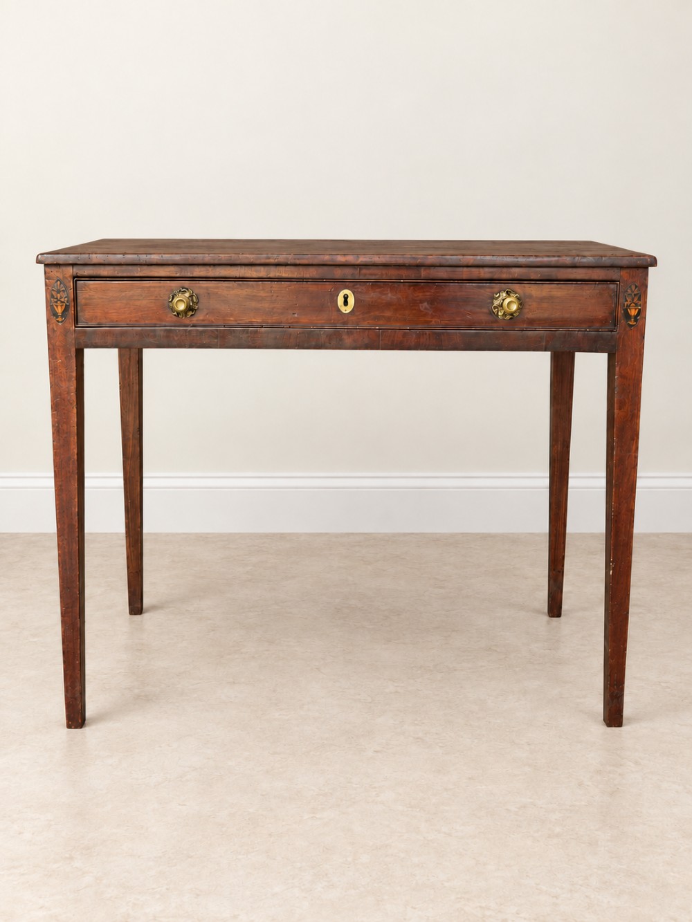 An antique nineteenth-century mahogany side table featuring a single drawer, brass handles, decorative oval floral inlay, and slender tapered legs. View V