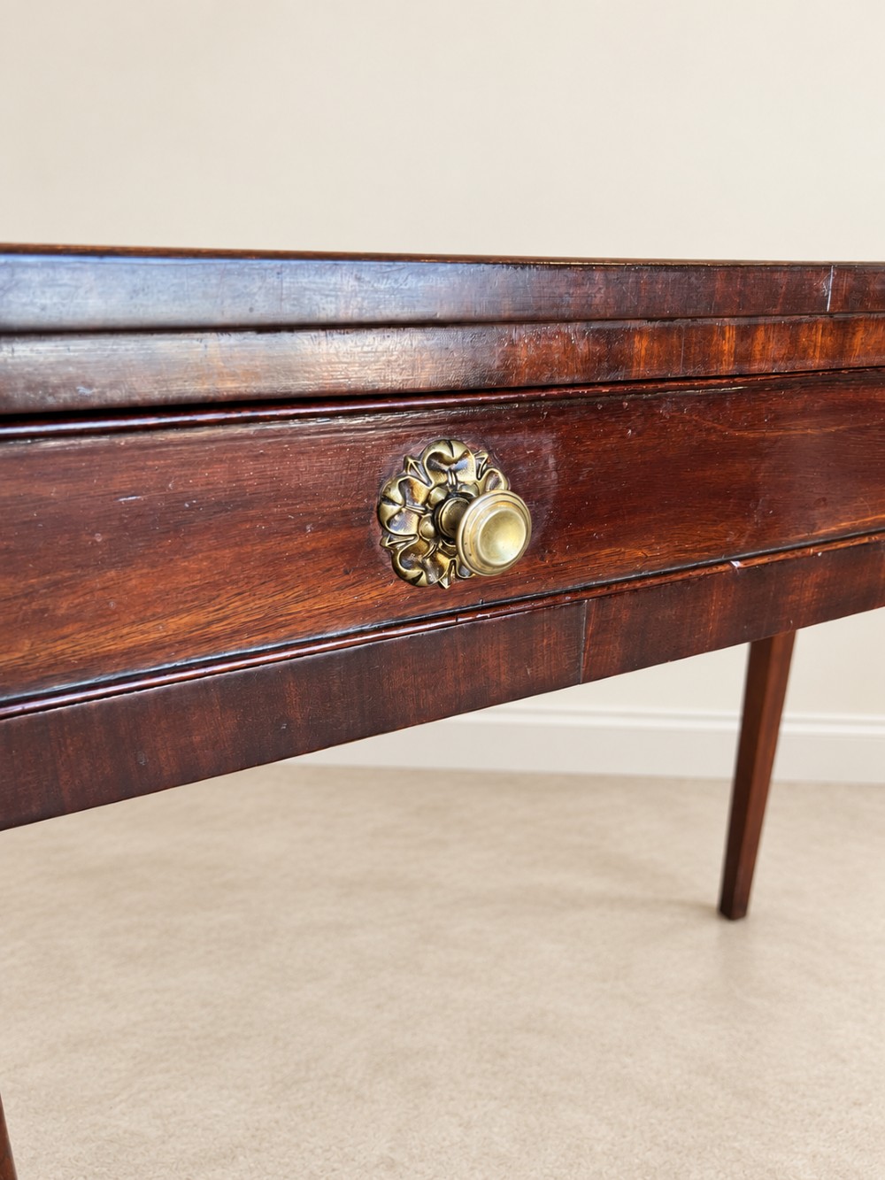 An antique nineteenth-century mahogany side table featuring a single drawer, brass handles, decorative oval floral inlay, and slender tapered legs. View VI