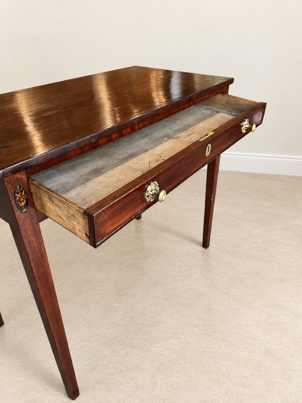 An antique nineteenth-century mahogany side table featuring a single drawer, brass handles, decorative oval floral inlay, and slender tapered legs. View XI
