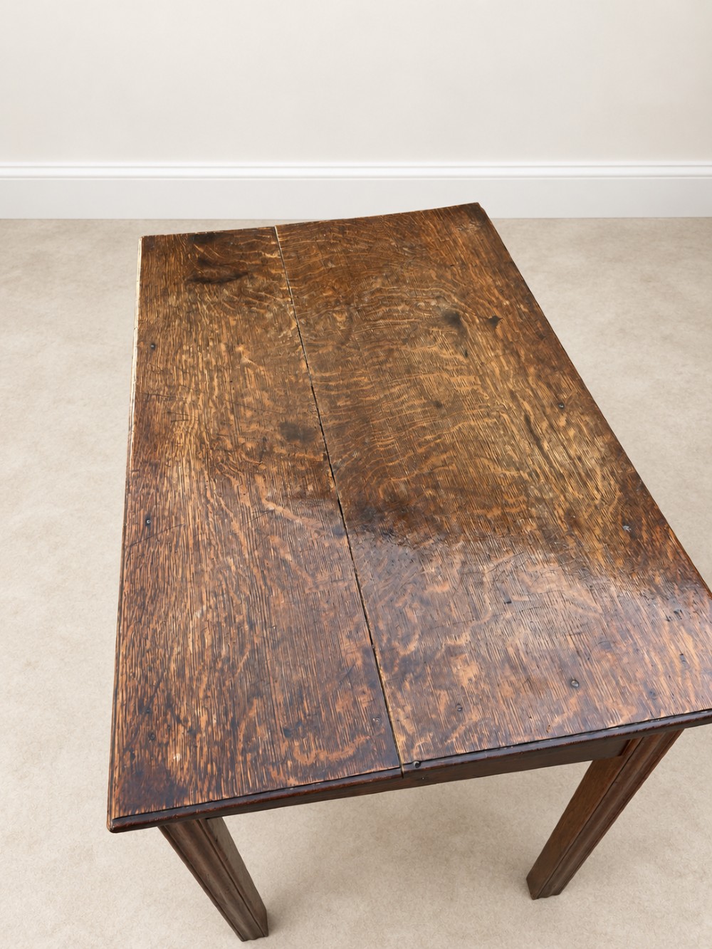 An 18th-century dark oak lowboy side table featuring three drawers with brass handles and a scalloped apron. View IV