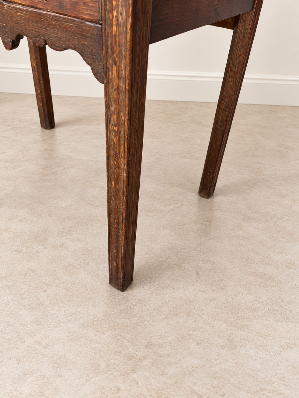 An 18th-century dark oak lowboy side table featuring three drawers with brass handles and a scalloped apron. View VII