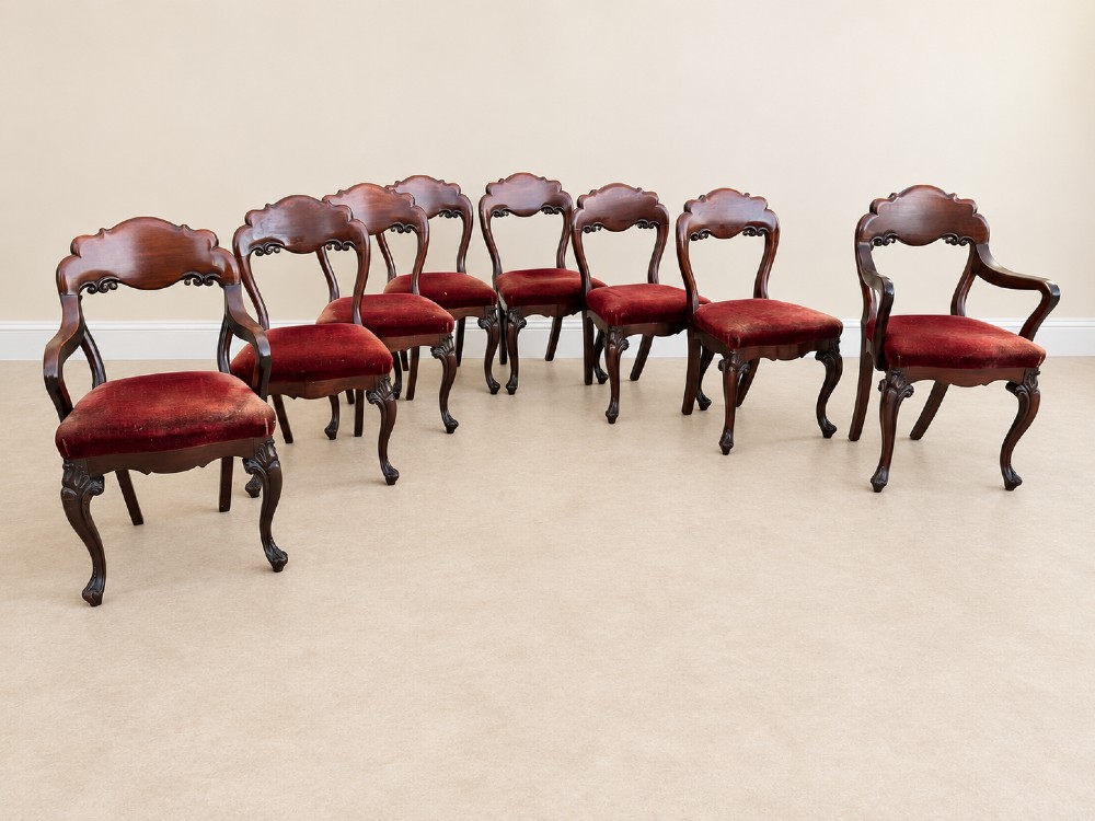 A set of eight 19th-century Victorian mahogany balloon back chairs with red velvet upholstery, including six side chairs and two carver armchairs with cabriole front legs.