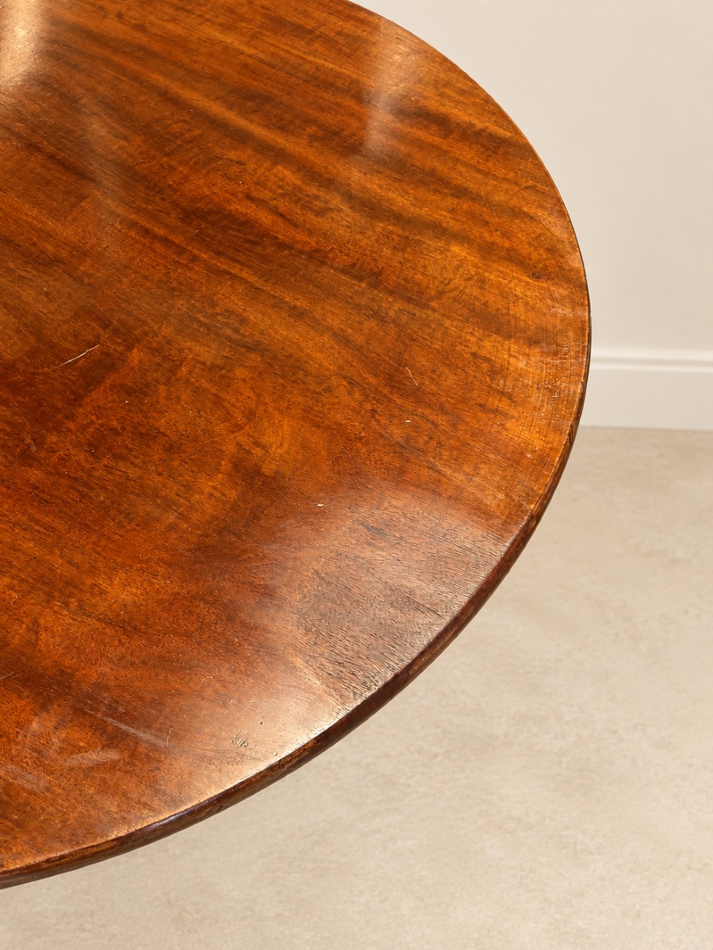 An 18th-century Georgian mahogany tilt-top table shown with its circular top locked vertically above a turned pedestal base with three cabriole legs. View VII