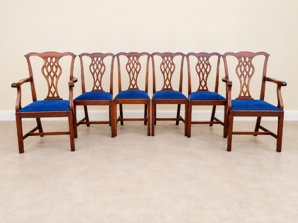 A set of six mahogany Chippendale style dining chairs comprising two carver armchairs and four side chairs with pierced fretwork backs and blue fabric drop-in seats. View II