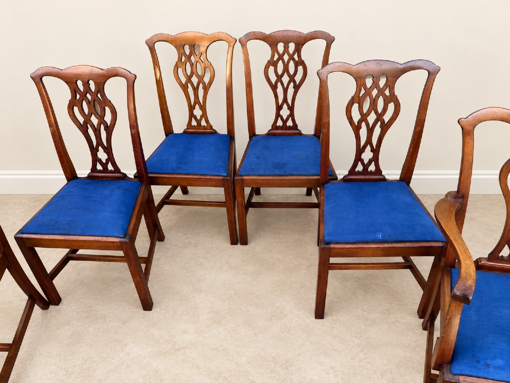 A set of six mahogany Chippendale style dining chairs comprising two carver armchairs and four side chairs with pierced fretwork backs and blue fabric drop-in seats. View V