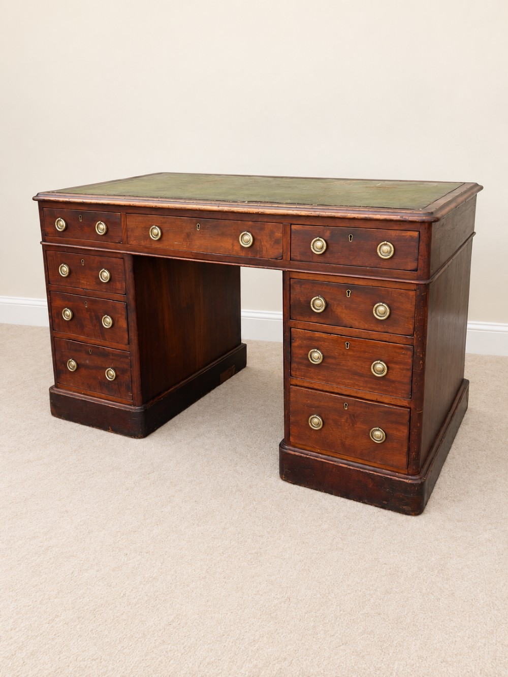 A 19th-century dark mahogany pedestal desk featuring nine drawers with brass handles and an inset green leather writing surface. View II