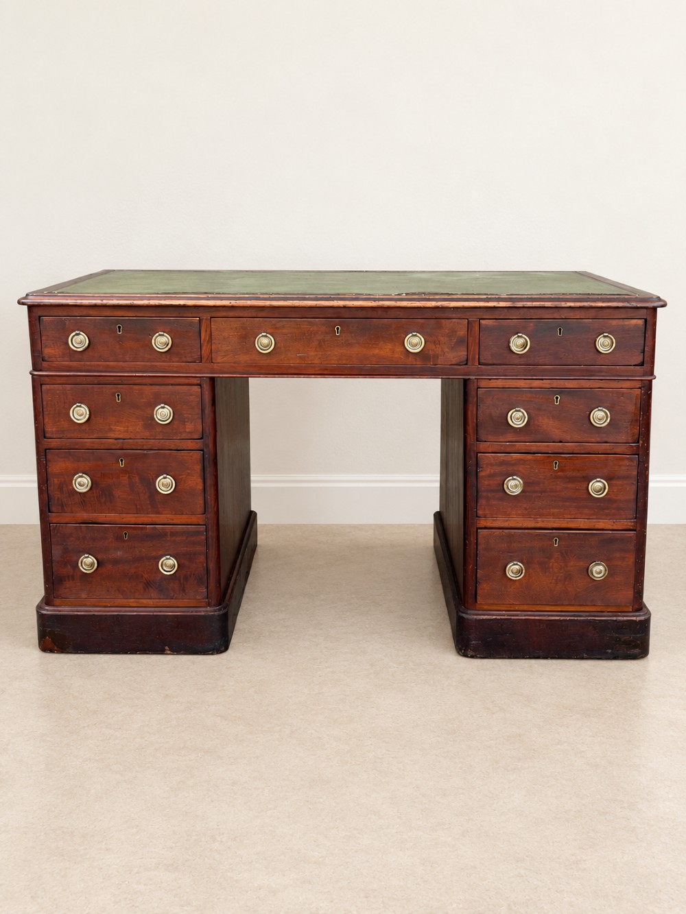 A 19th-century dark mahogany pedestal desk featuring nine drawers with brass handles and an inset green leather writing surface. View III