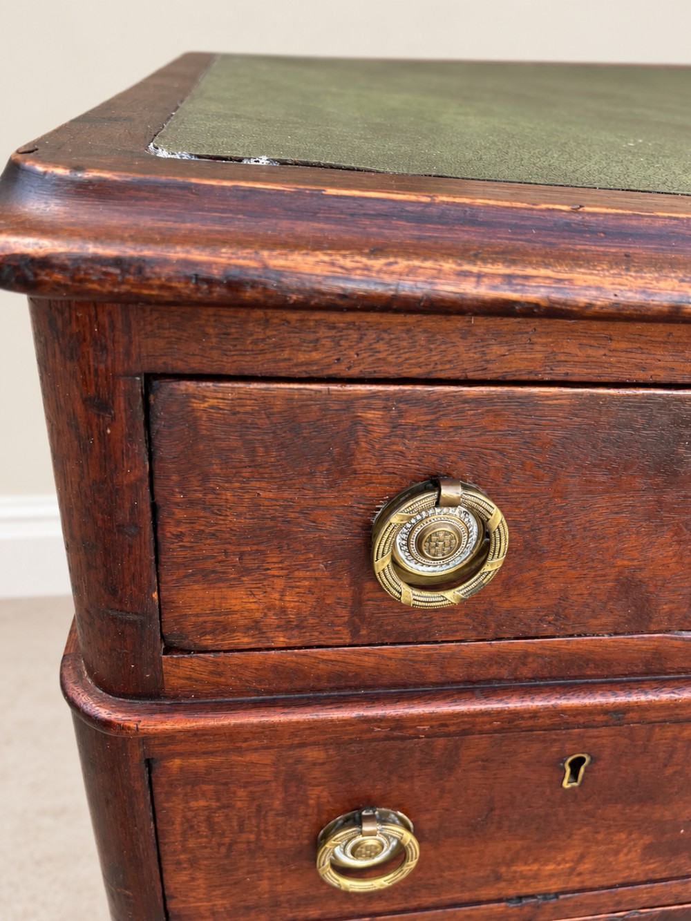 A 19th-century dark mahogany pedestal desk featuring nine drawers with brass handles and an inset green leather writing surface. View VII
