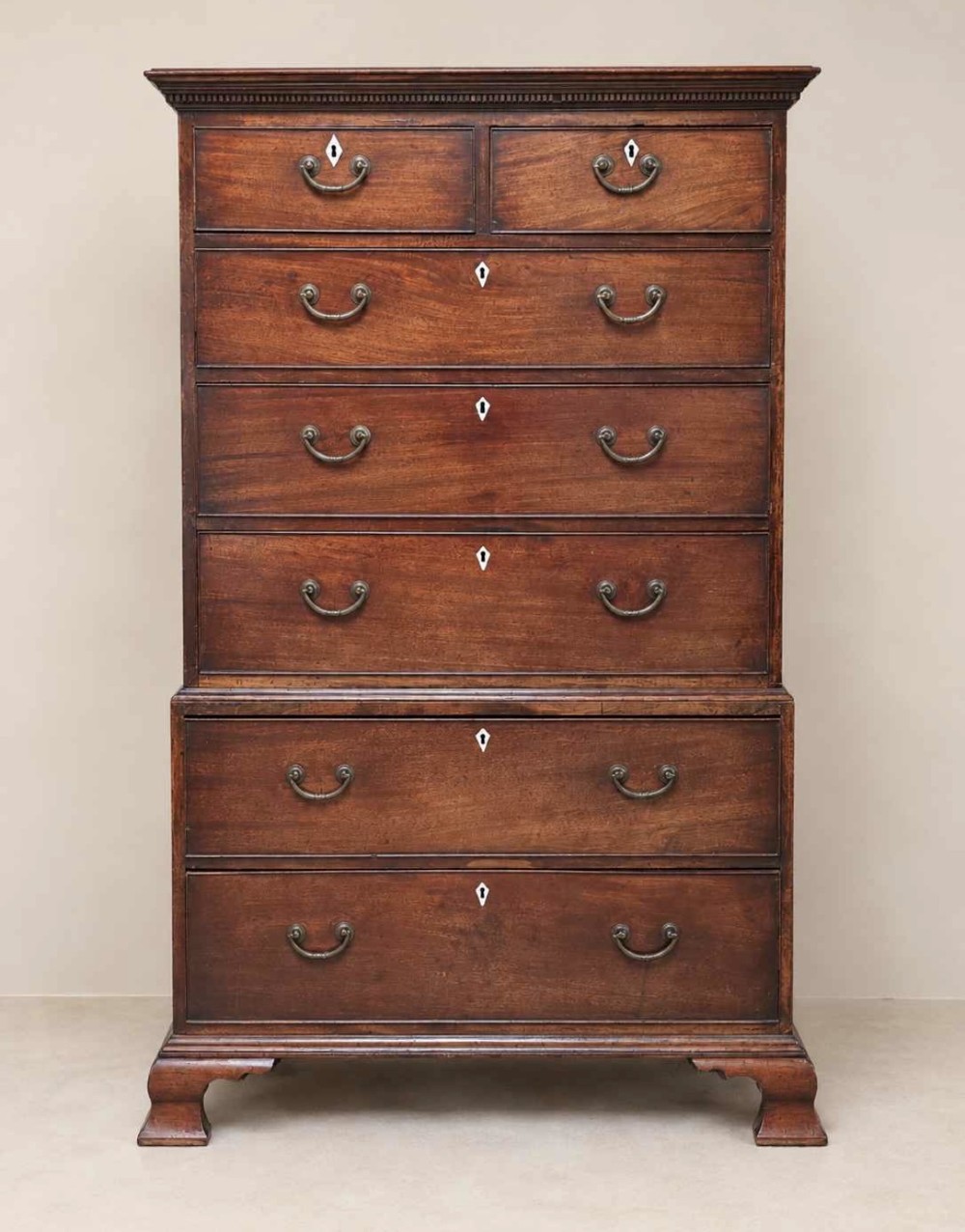 A tall Georgian mahogany chest on chest featuring brass swan-neck handles, diamond keyhole escutcheons, and ogee bracket feet. View II